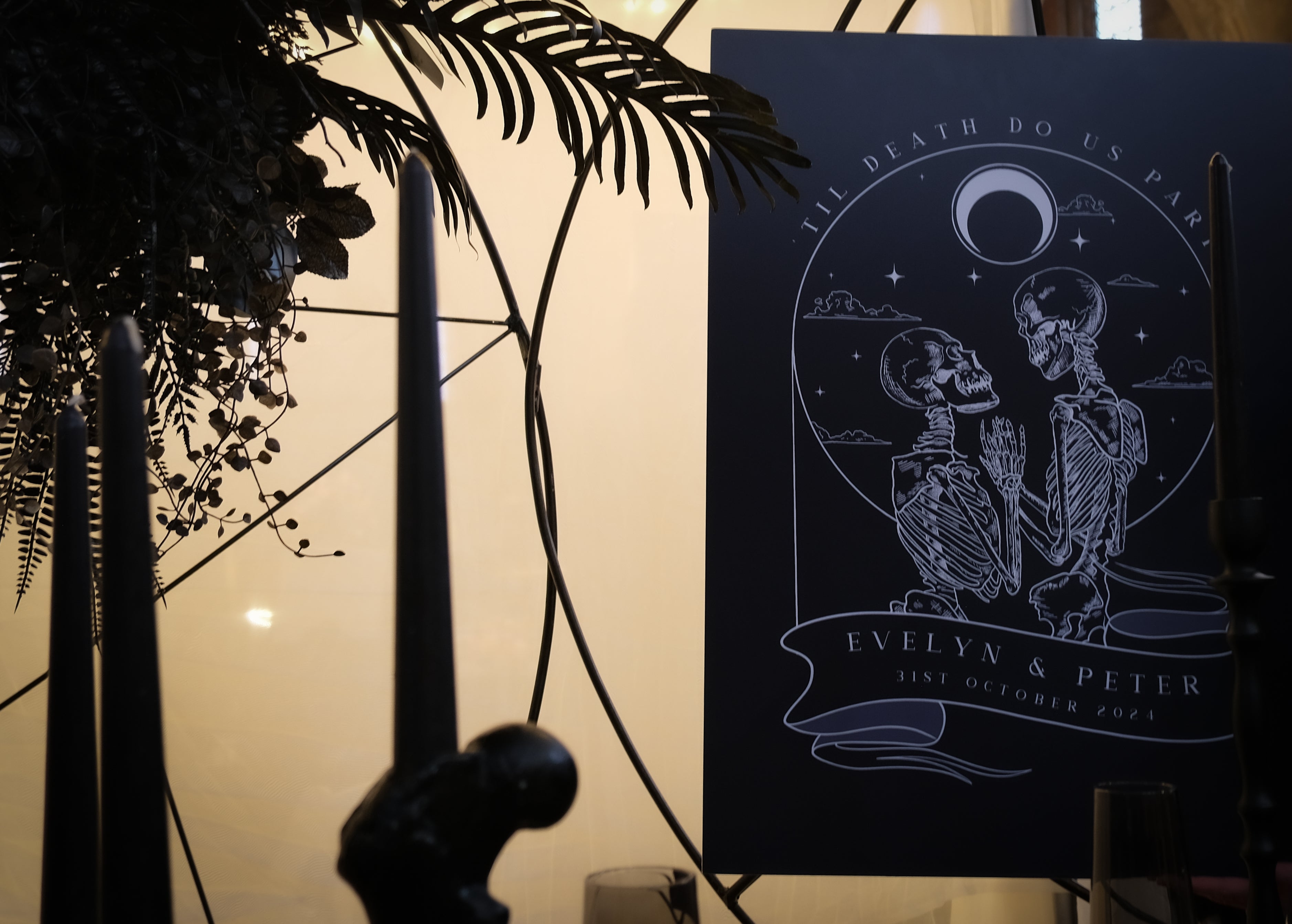 A luxury gothic wedding welcome board in a vintage tarot style, with celestial motifs, dramatic skeletons, candles, and foliage.