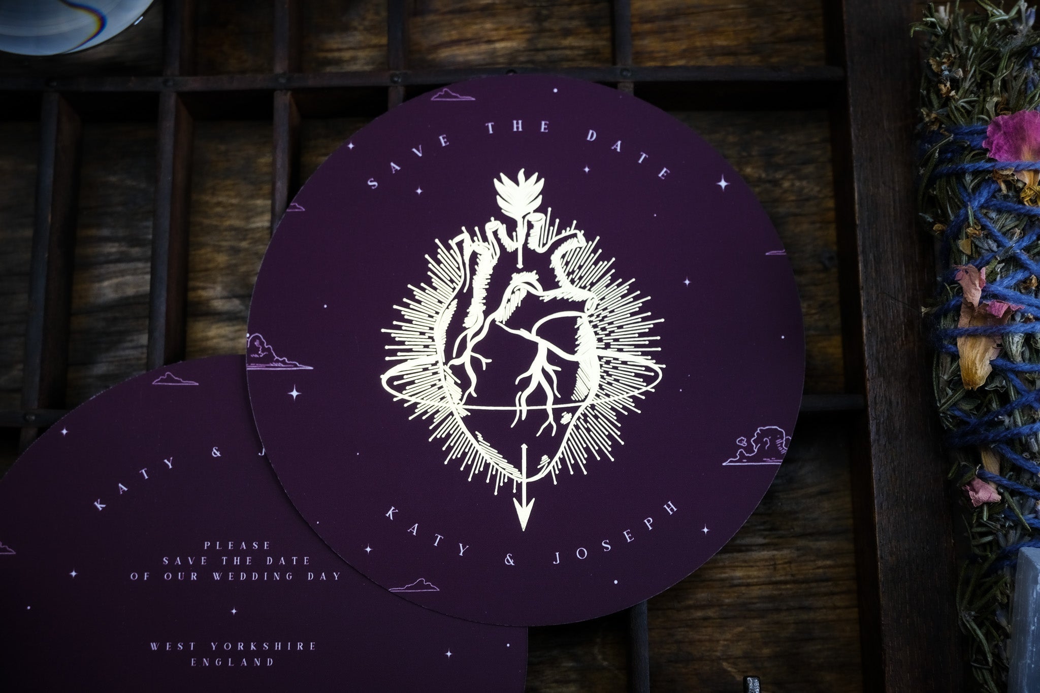 Luxury gothic circular save the date card with dramatic gold foil anatomical heart and floral motif, alternative romantic UK stationery.