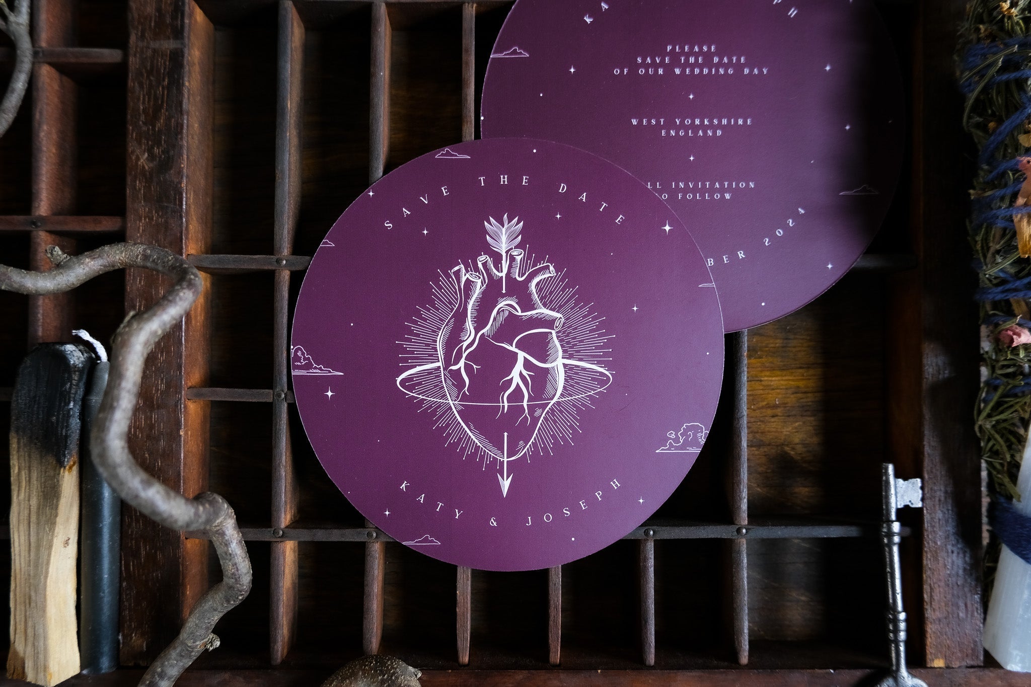 A luxury round purple save the date card with gothic and celestial motifs, featuring an anatomical heart on premium UK stationery.