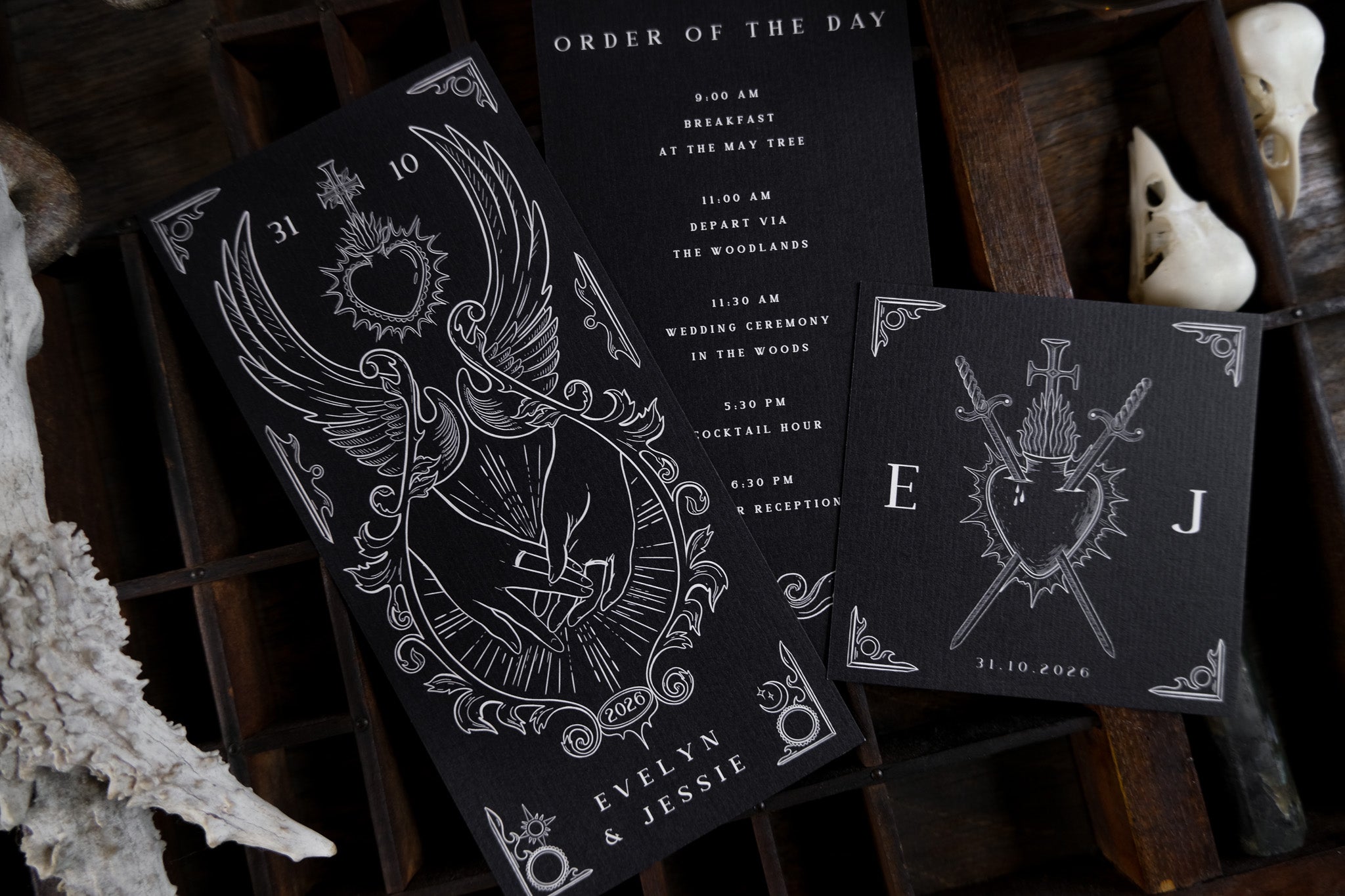 Luxury UK wedding stationery suite with black gothic cards, white swords, hearts, and birds in a dramatic, romantic illustrated design.