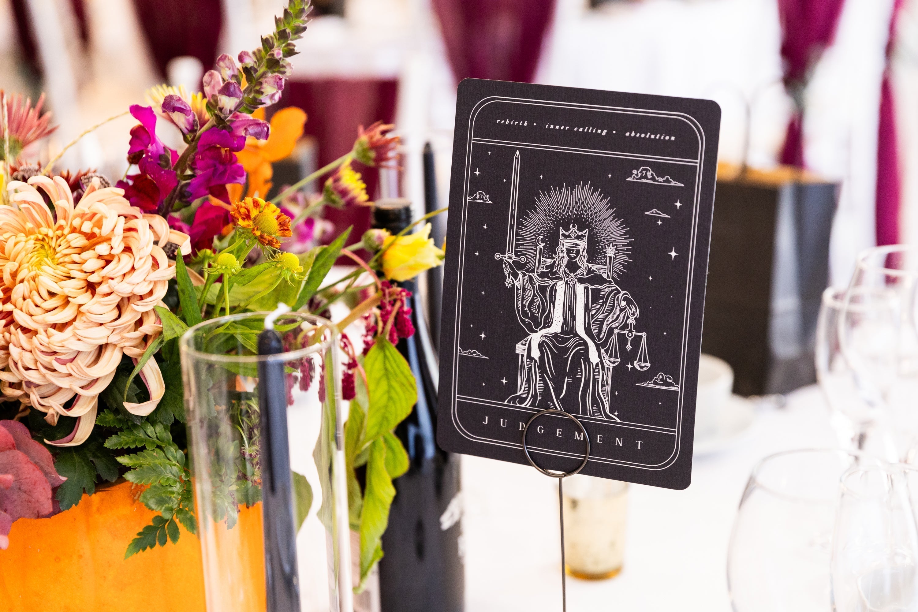 Gothic tarot card art print featuring Judgement design used as a wedding table number with floral centerpiece