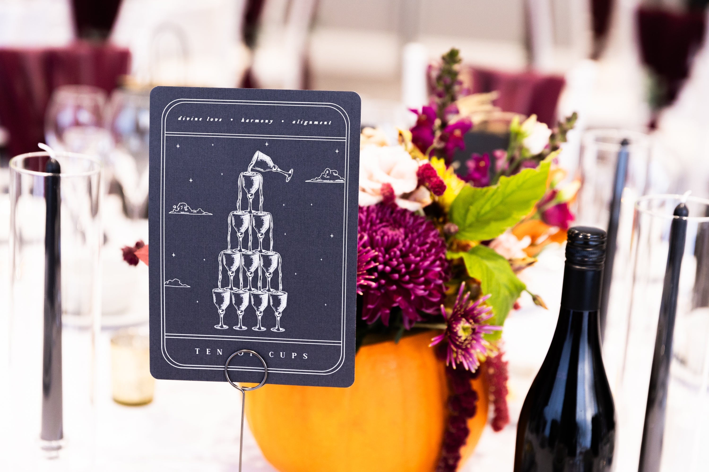 Tarot Card Art Print Ten of Cups on black matte cardstock used as wedding table number with floral centerpiece and wine bottle