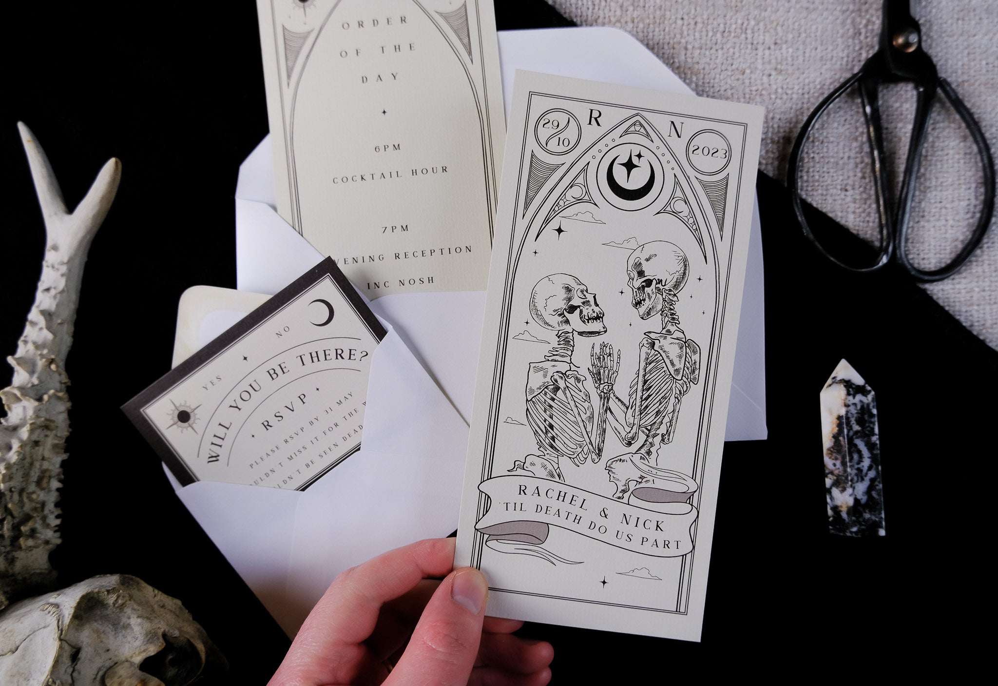 'Til Death Do Us Part' Lovers Tarot Card 3 Piece Invitation Suite featuring skeleton design, order of the day, RSVP card, and white envelopes.