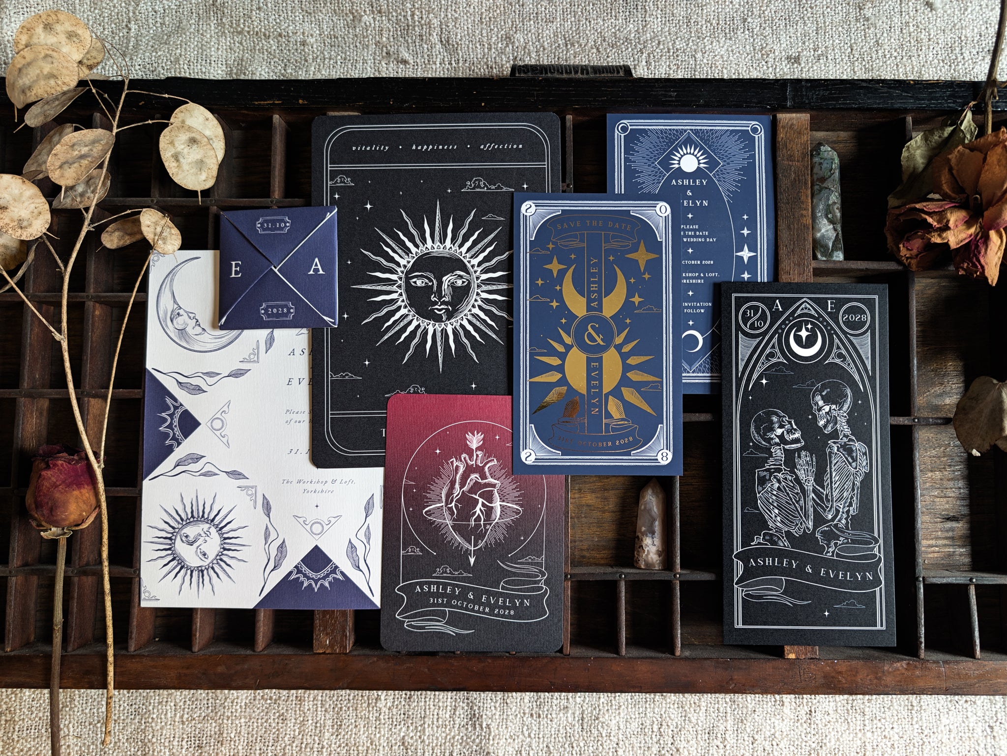 Save the date sample pack from Birdhouse197, showing four gothic and celestial designs on a wooden tray.
