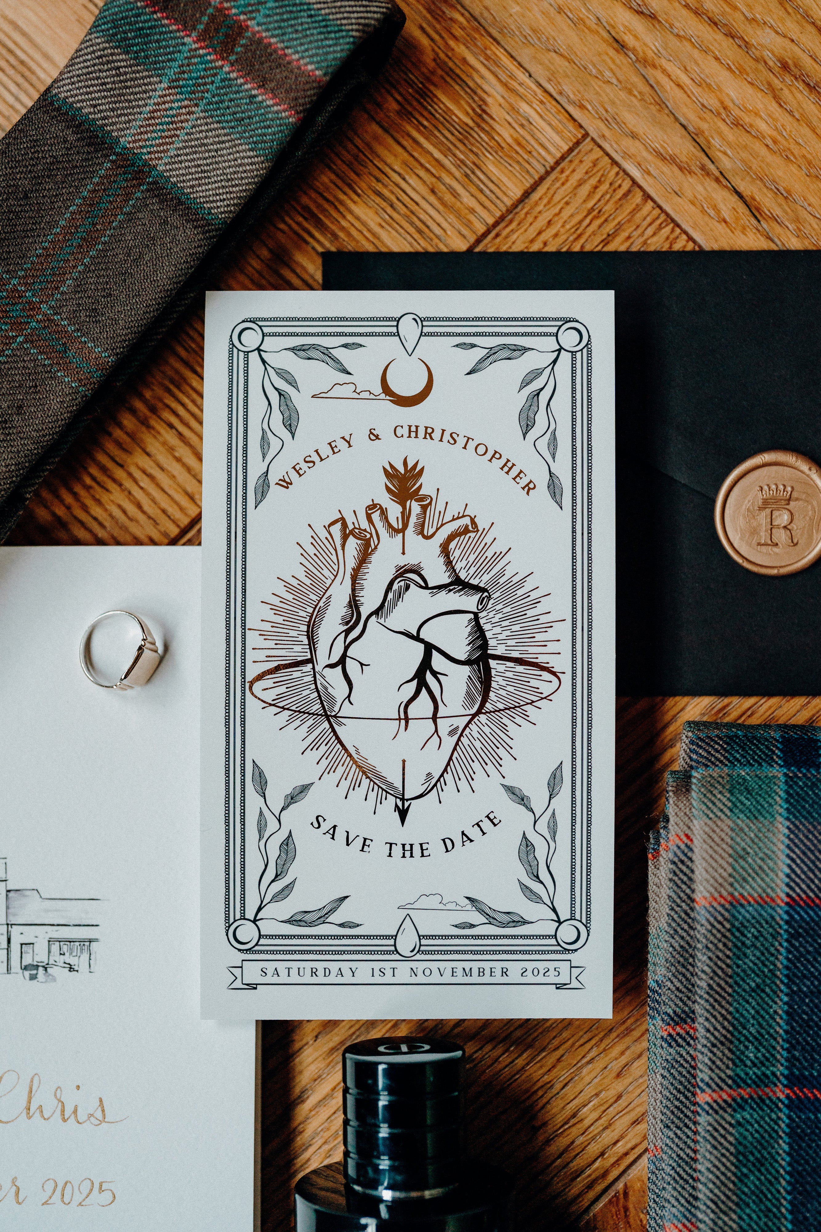 Luxury UK wedding stationery Save the Date card with vintage stag and deer illustration, laurel border, on plaid with ring and envelope.