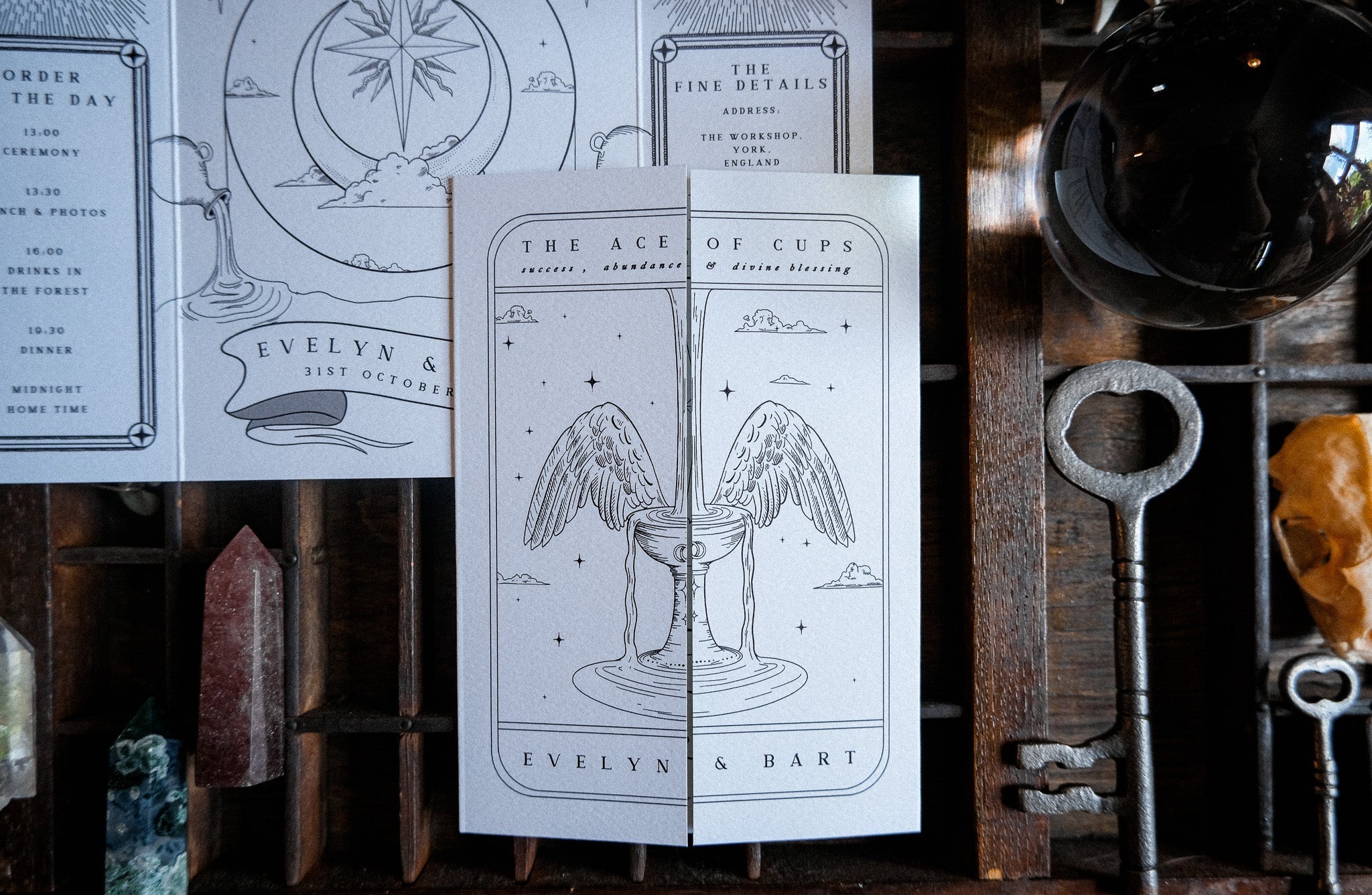 Luxury UK gatefold wedding invitation with mystical tarot and celestial motifs, winged cup, vintage keys, and romantic crystals.
