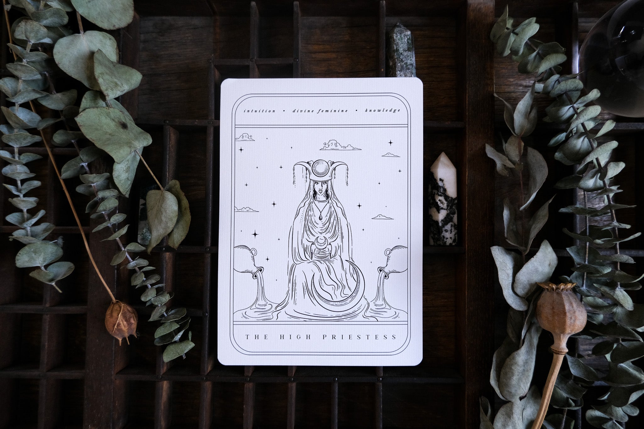Luxury gothic wedding stationery set with celestial tarot designs, styled on wood with dried leaves and crystals for a mystical touch.