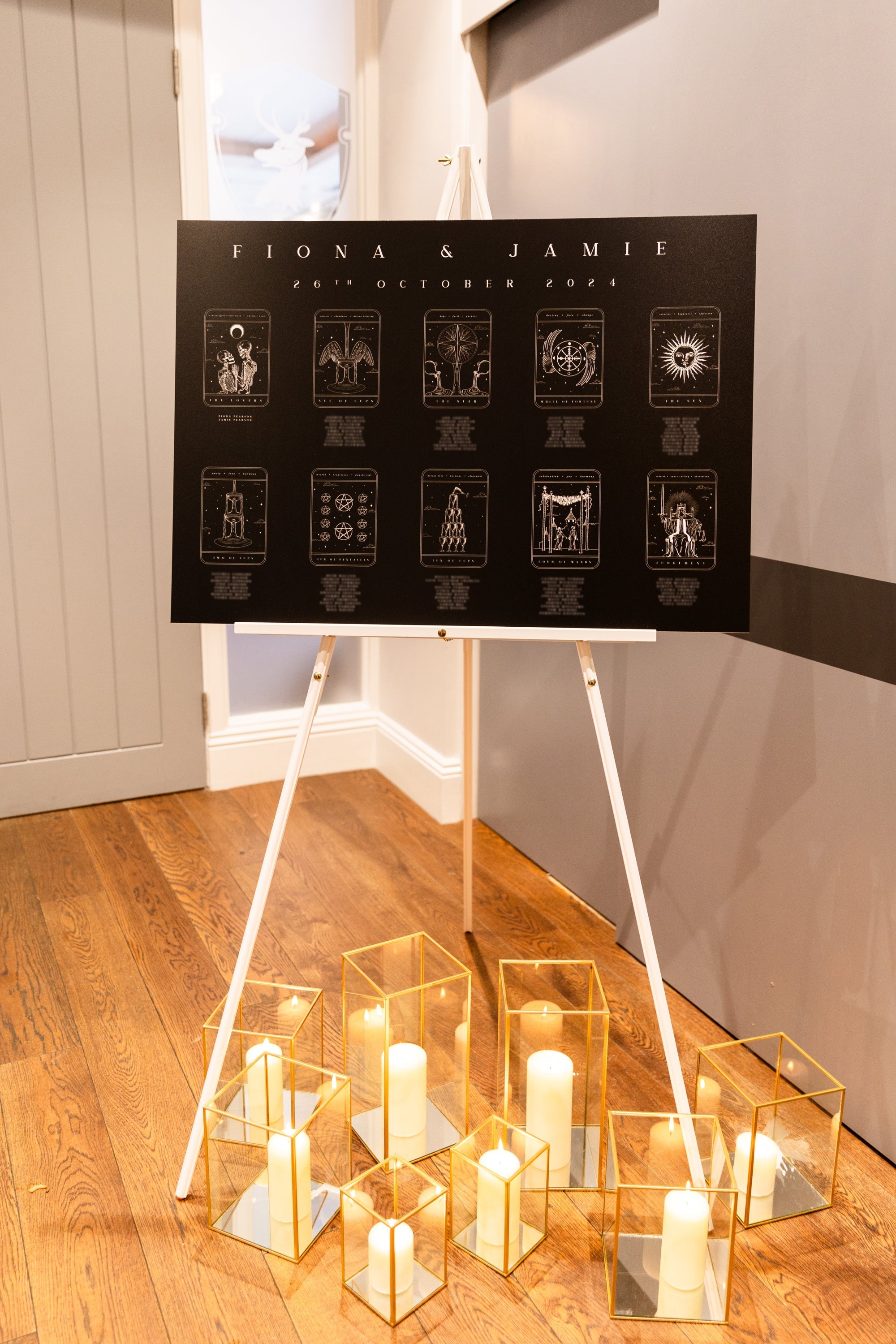 Luxury personalised tarot card wedding seating plan on an easel, gothic black design with mystical candles in a romantic UK setting.