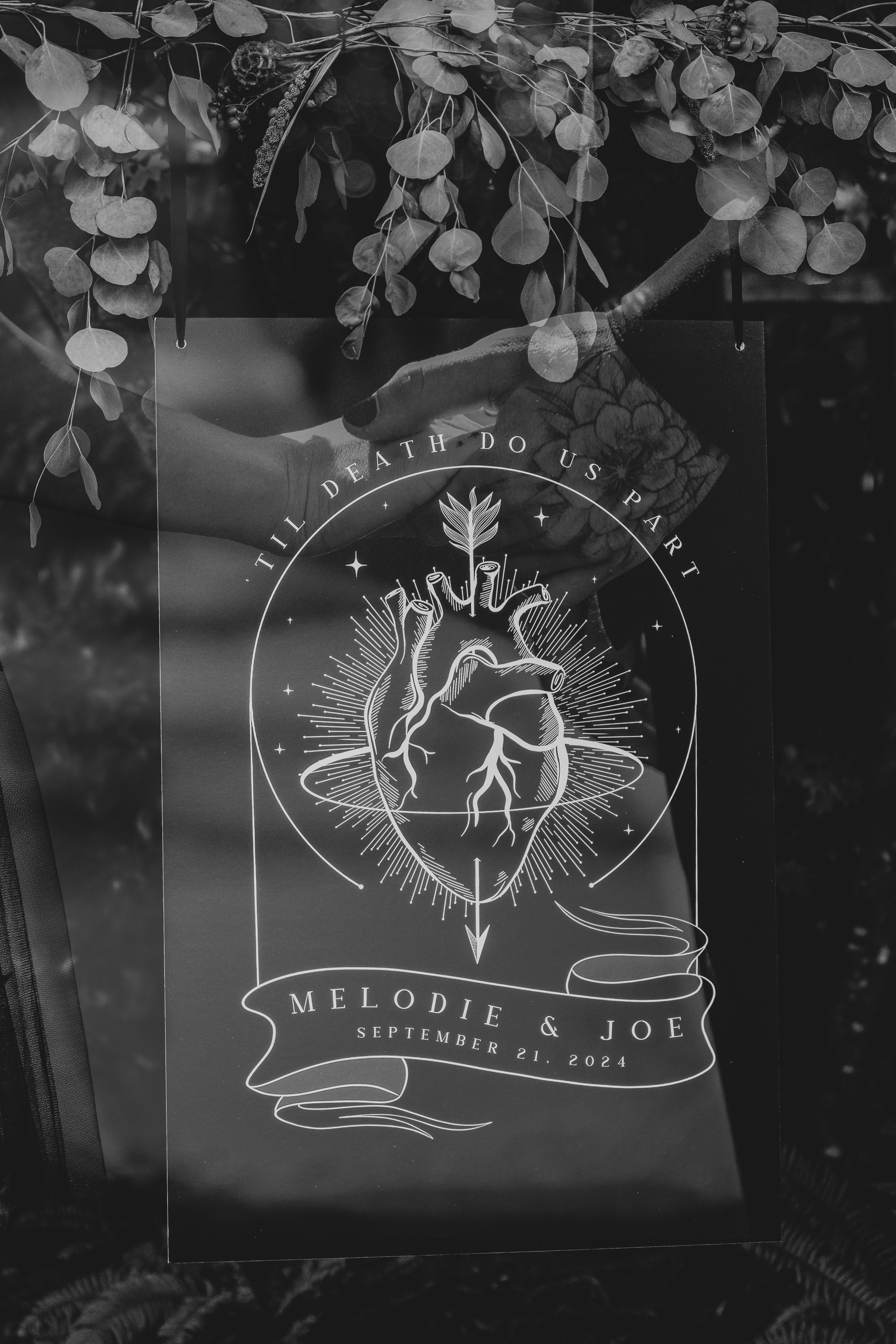 A gothic-inspired luxury wedding welcome board with monochrome anatomical heart, vintage florals, and dramatic botanical accents.