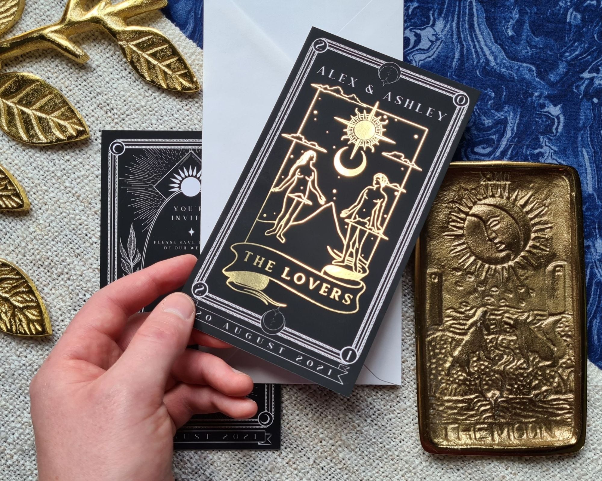 Foiled "The Lovers" save the date card with gold detailing, featuring tarot-inspired design.
