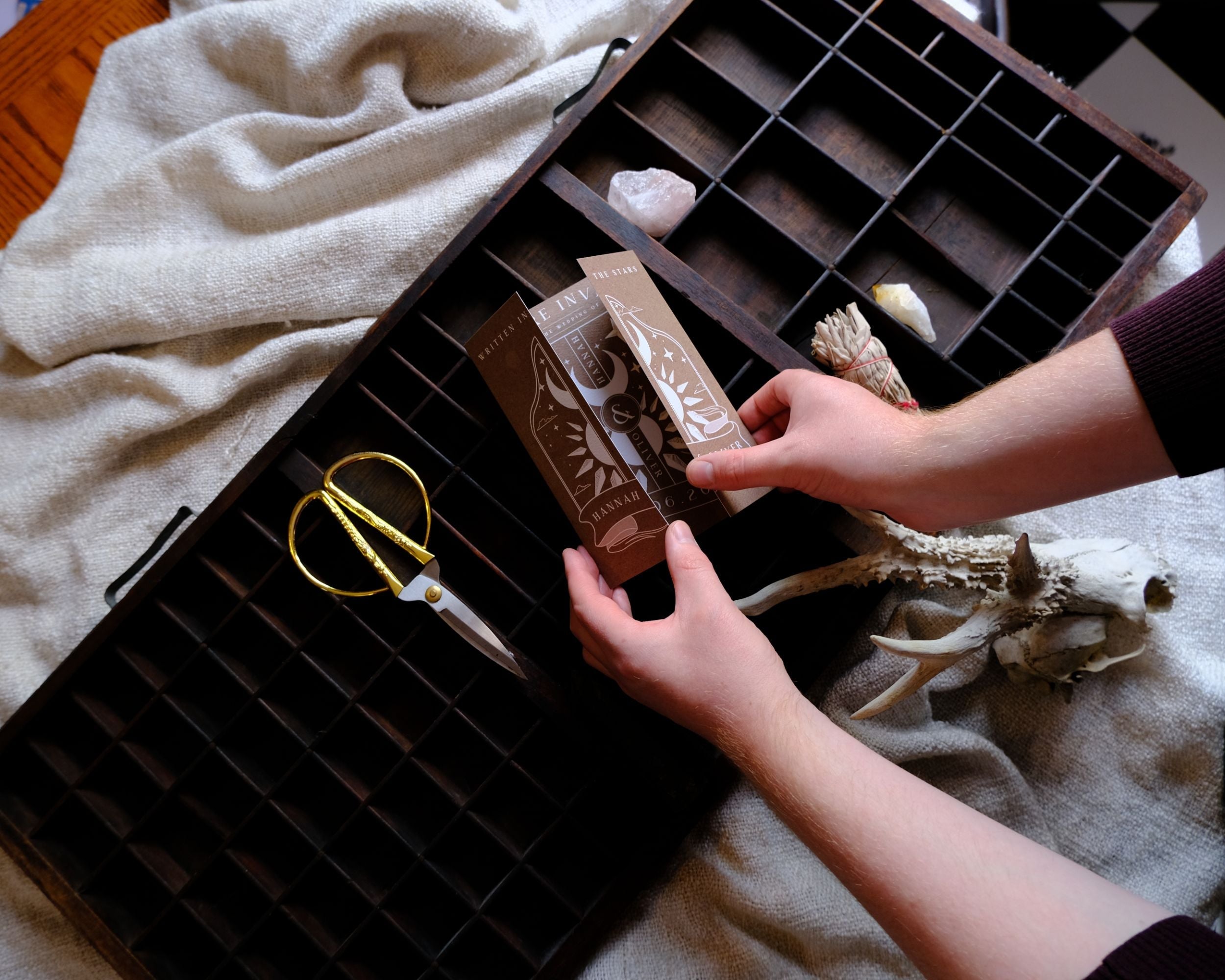 'Dusk & Dawn' Gatefold Wedding Invitation in brown tones displayed with envelopes and decorative items.
