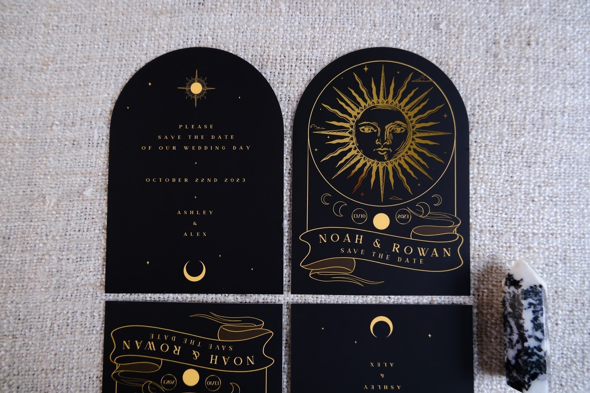 The Sun Tarot Arched Foiled Save The Date Card with celestial design and foil details, set on a woven background.