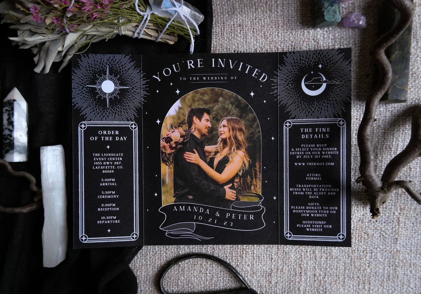 Black celestial-style wedding invitation with couple photo and event details