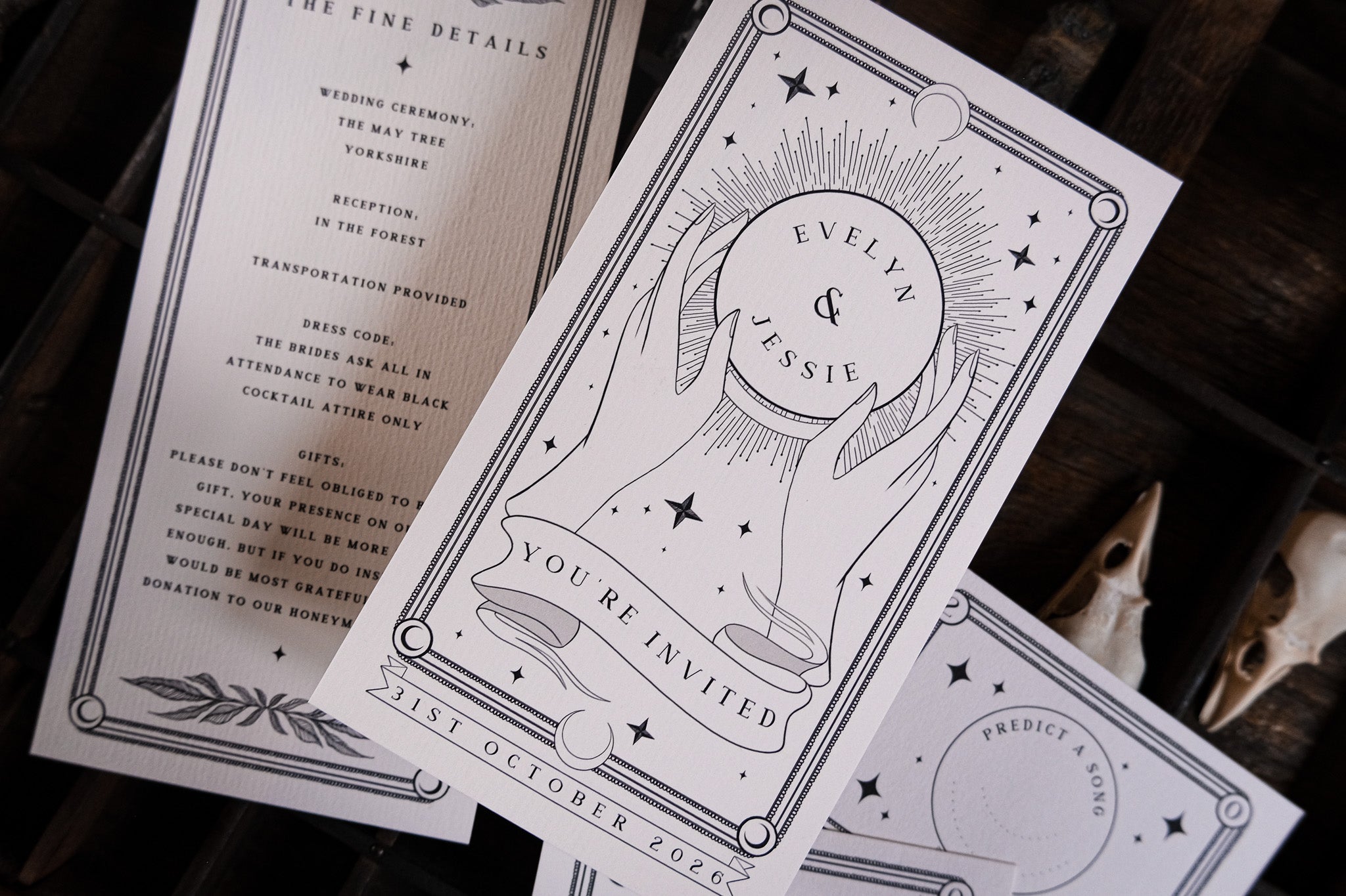 Close-up of luxury UK wedding stationery suite, featuring gothic black and white celestial designs with a mystical, vintage flair.