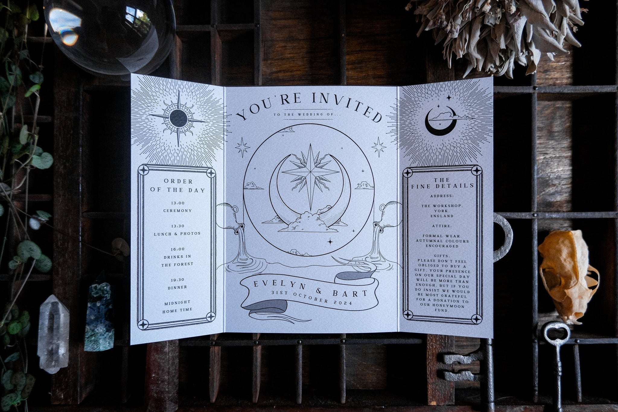 Luxury celestial gatefold wedding invitation with tarot-inspired sun, moon, and stars on rustic wood. Mystical, alternative UK stationery.