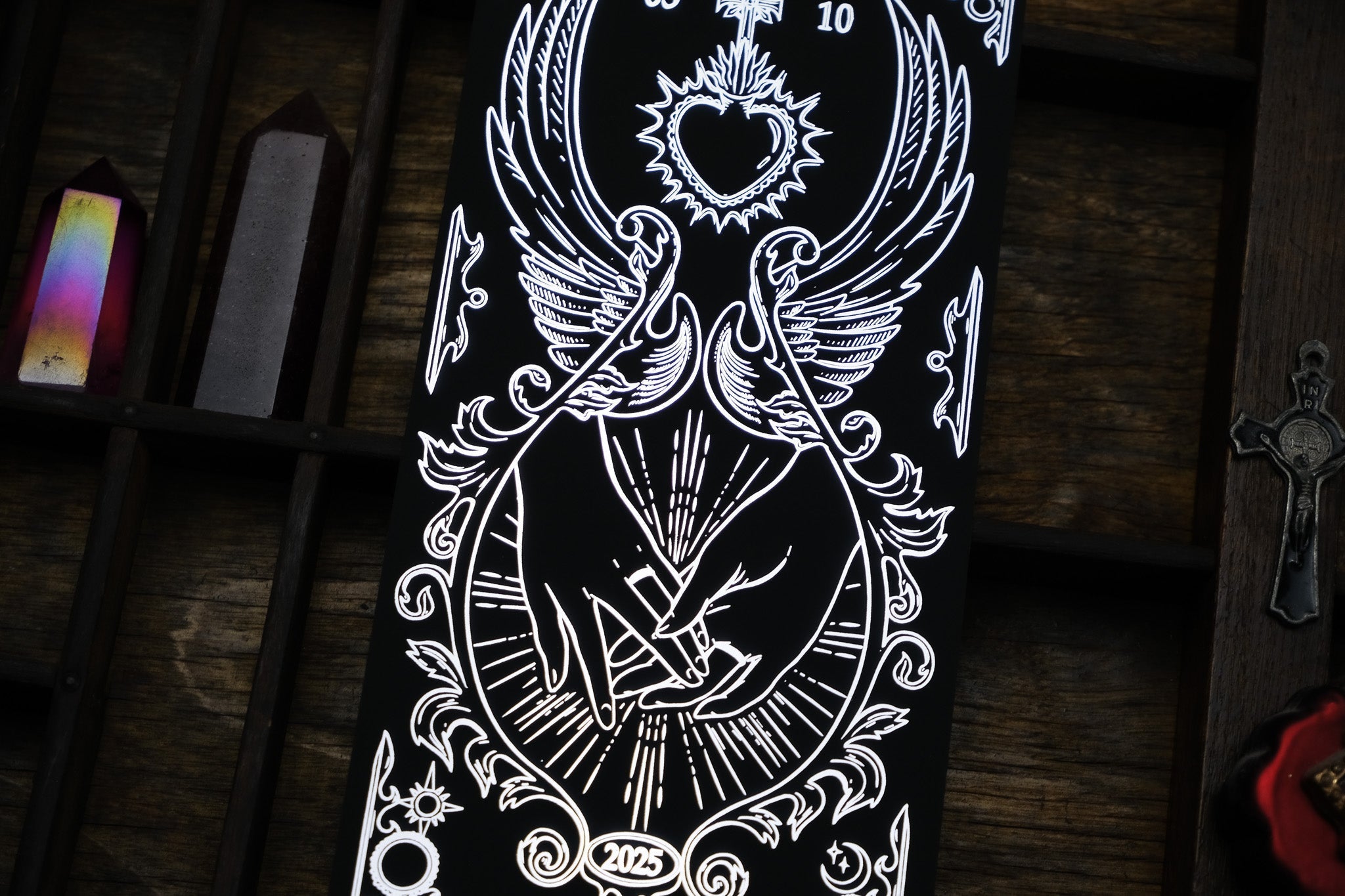 Luxury foiled save the date card featuring gothic, intricate illustration of hands exchanging a ring, ornate crystals and cross accents.