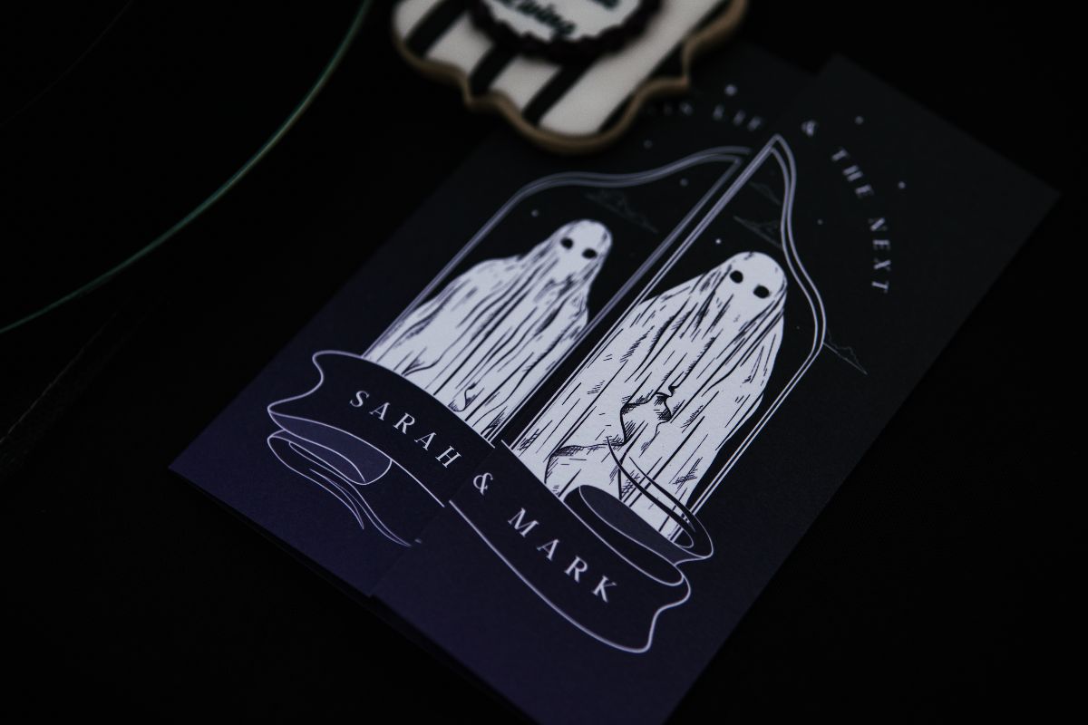 Luxury gothic wedding stationery: a dark, whimsical invitation with ghostly figures in a bell jar, ideal for alternative UK weddings.