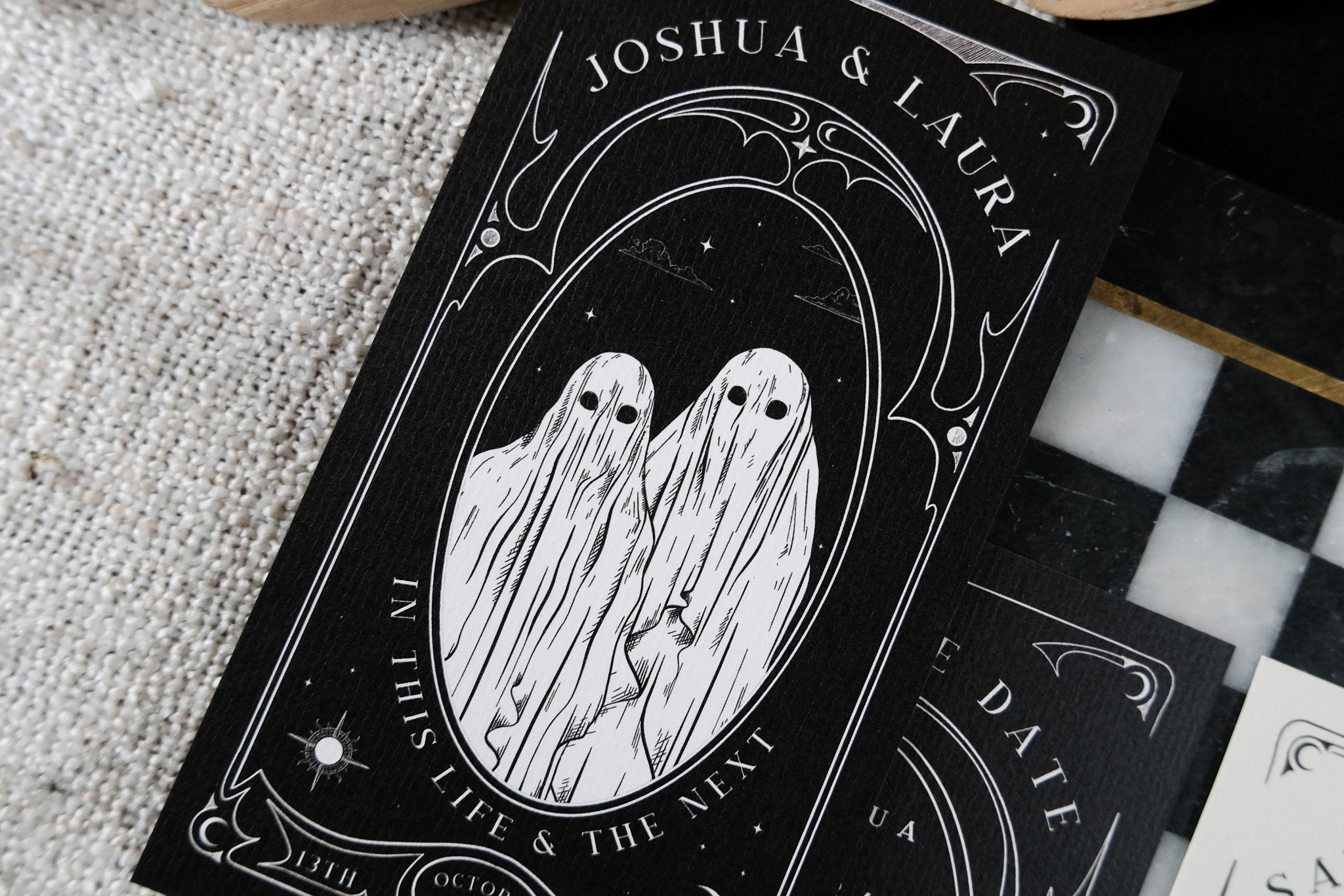 Luxury UK wedding stationery save the date with two ethereal ghost figures, ornate borders, black background, gothic tarot style.