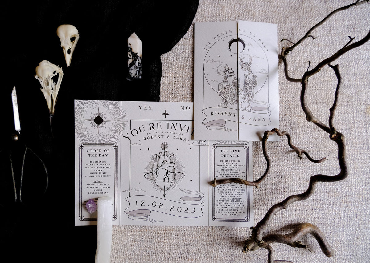 Gatefold wedding invitation with skeleton lovers and bleeding heart gothic design titled 'Til Death Do Us Part' on matte textured card