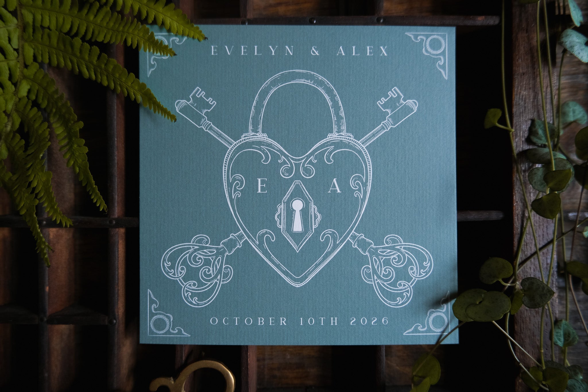Luxury vintage UK save the date card with heart-shaped padlock, skeleton key motif, leafy accents, and romantic gothic styling.