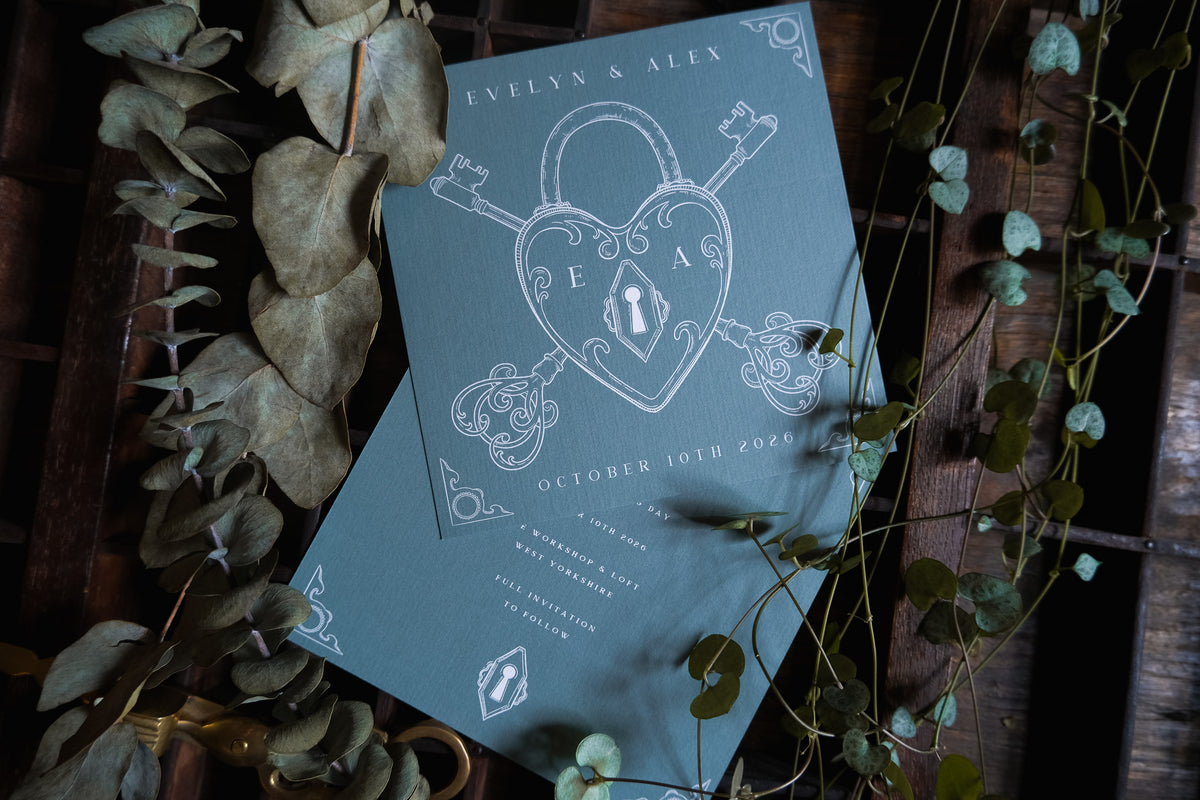 Alternative gothic lock and key save the date card featuring gold metallic foiling and velvet texture finish.