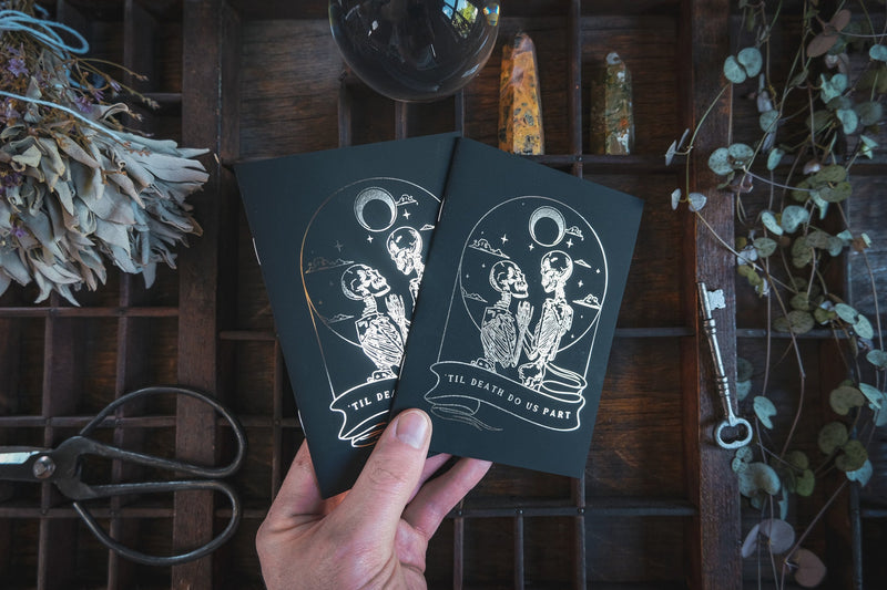 Gothic wedding vow books with skeleton lovers design and gold foil detail.