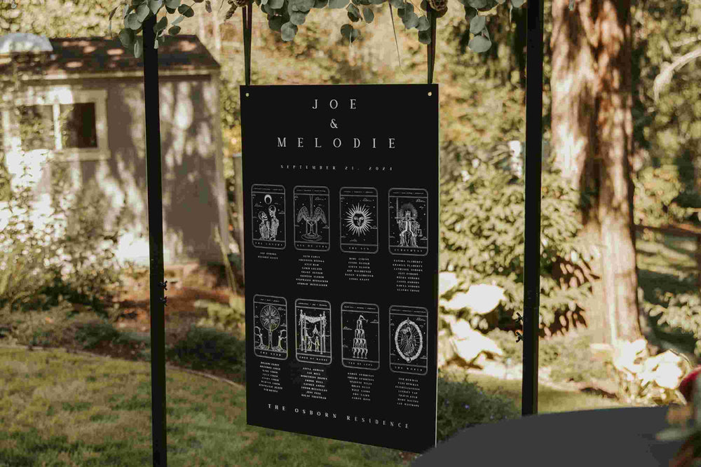 Black tarot card seating plan hanging outdoors among greenery