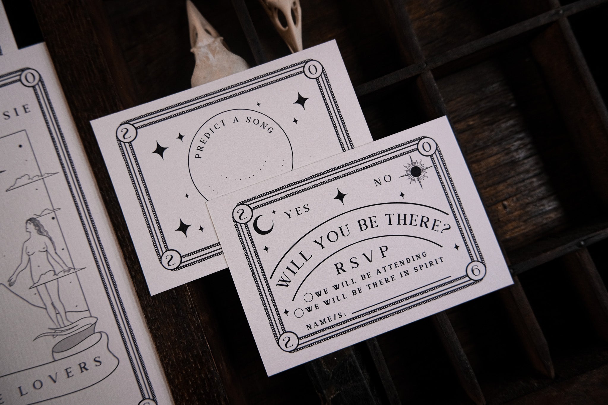 Luxury black-and-white tarot-inspired RSVP cards with gothic design on dark wood, perfect for alternative UK wedding stationery.