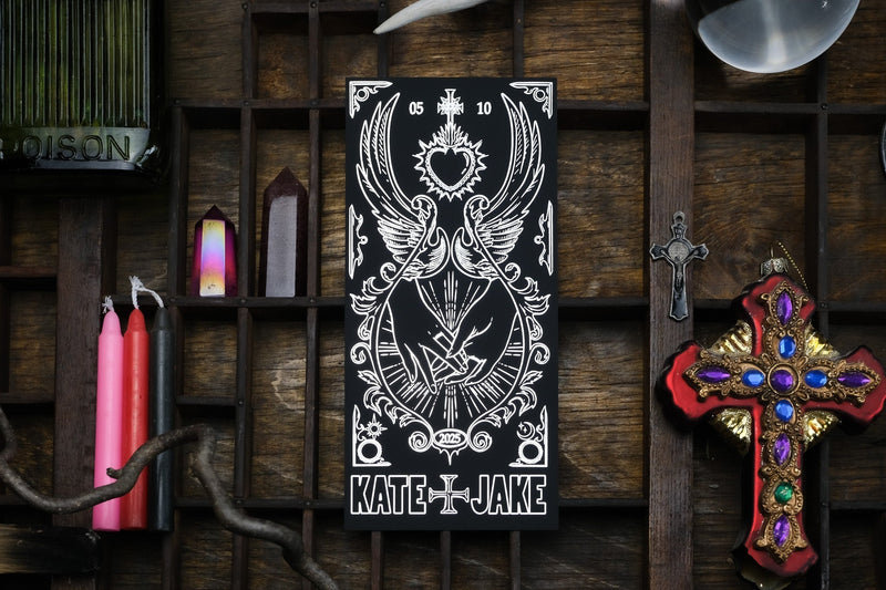 Luxury foiled save the date with gothic, romantic motifs amid candles, crystals, and vintage dark decor; premium UK wedding stationery.