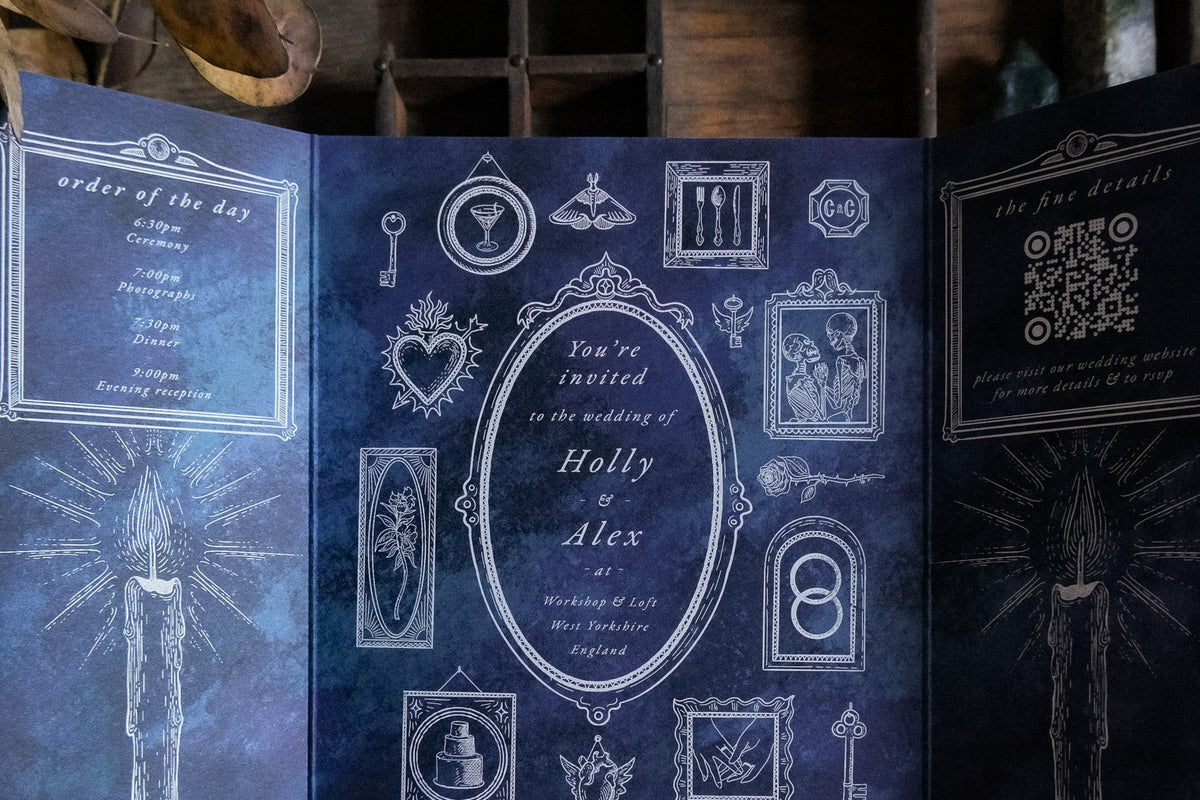 Luxury UK wedding stationery: gothic gatefold invitation in dark blue, Victorian design with vintage white illustrations and hand-drawn art.