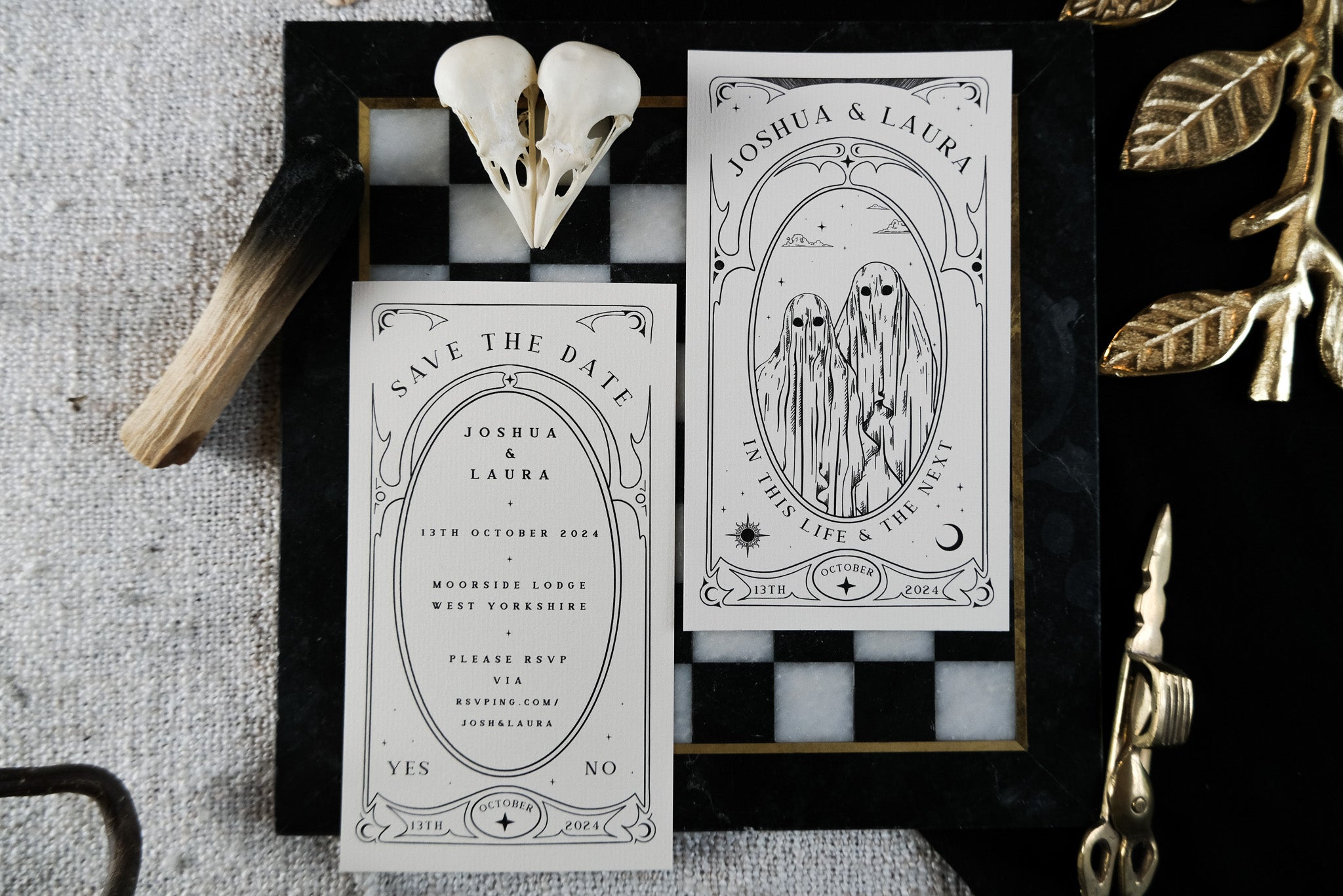 Luxury gothic save the date cards with mystical black and white tarot designs on a chessboard tray, styled with a skull and gold leaves.
