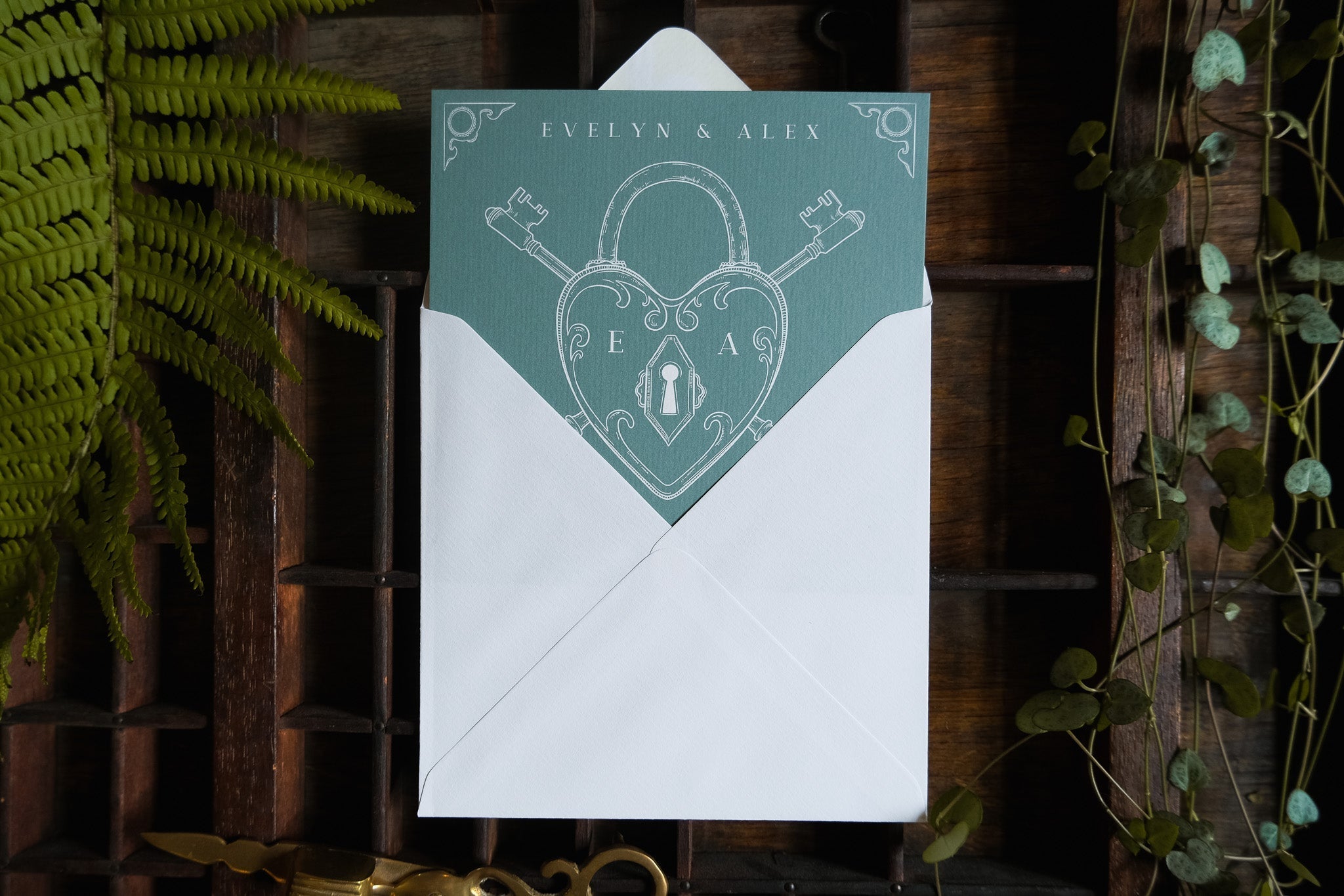 Luxury vintage save the date card with heart padlock and skeleton key, accented by ferns and vines, in elegant boho UK style.
