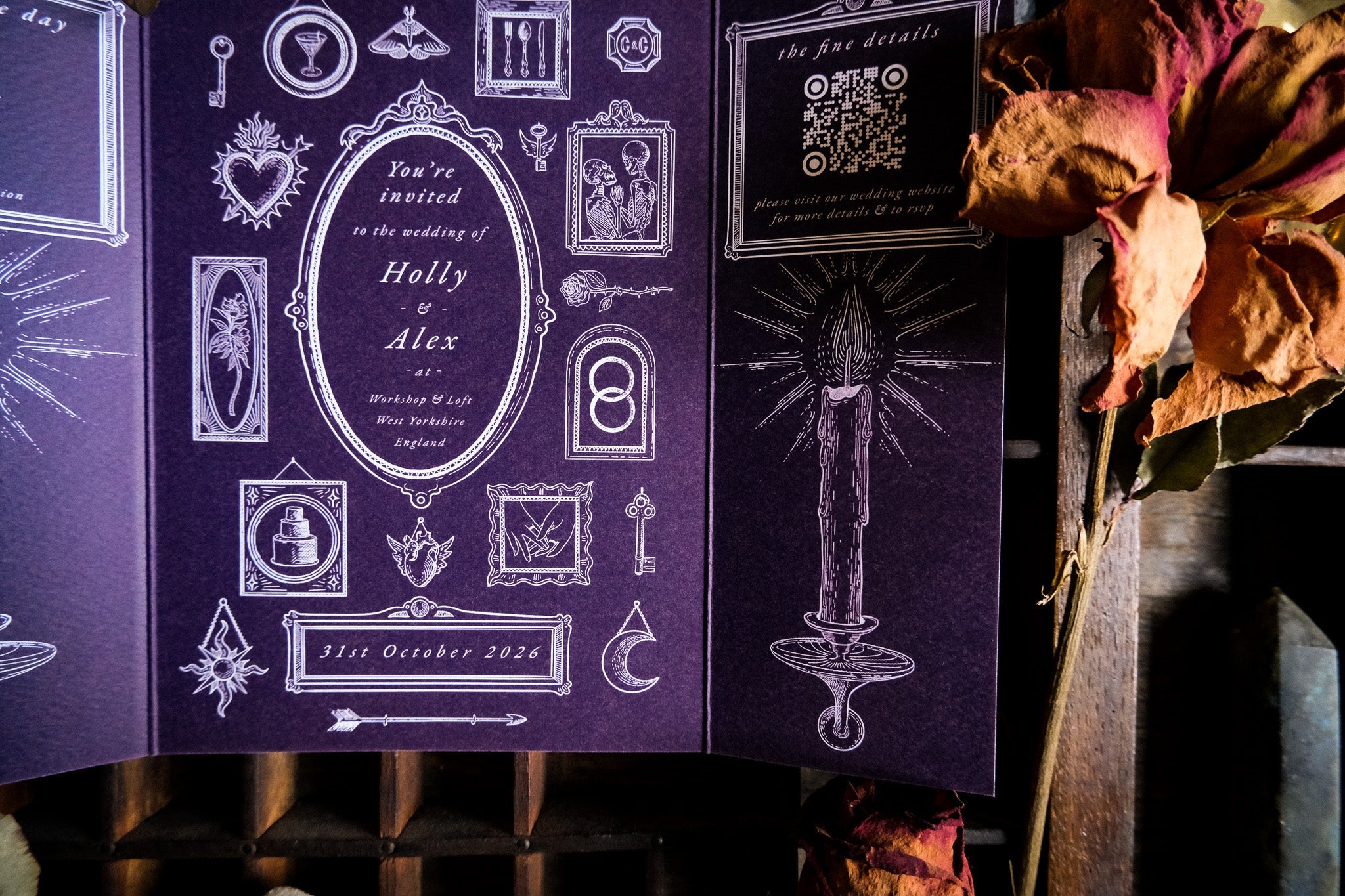 Luxury gothic gatefold wedding stationery with custom silhouettes, ornate white frames, candle, keyhole, QR code and dried florals.
