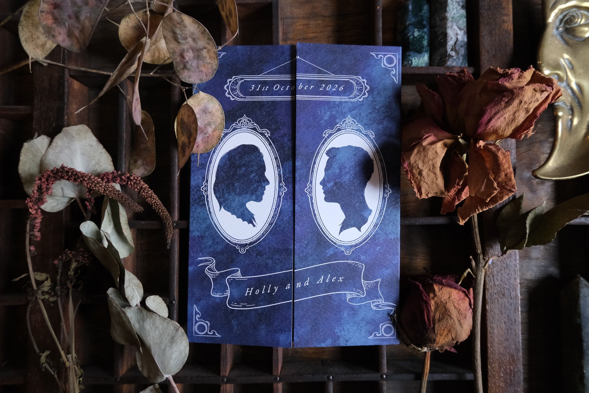 Luxury UK gatefold wedding invitation with dramatic Victorian gothic silhouette design, ornate frames, and mystical dried botanicals.