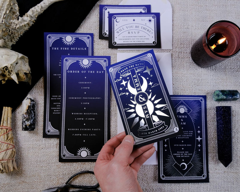 'Dusk & Dawn' foiled tarot card 3 piece invitation suite displayed on a table.